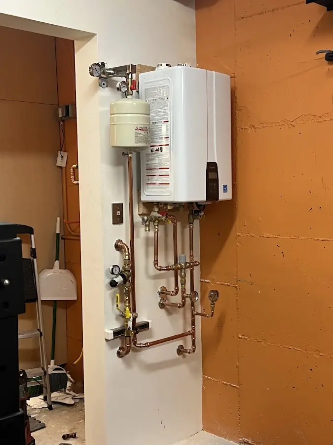 Plumbing technician inspecting water heater connections in Wylie